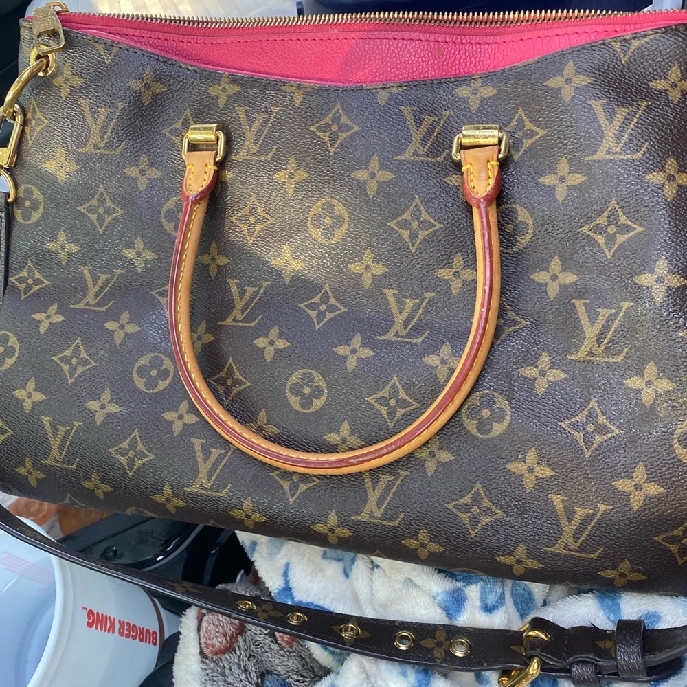 Louis  Vittion bag with zipper and pink accents.